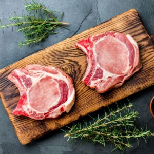 Heritage pork chops on a wooden cutting board from Forester Family Farm in Shell Knob, Missouri.